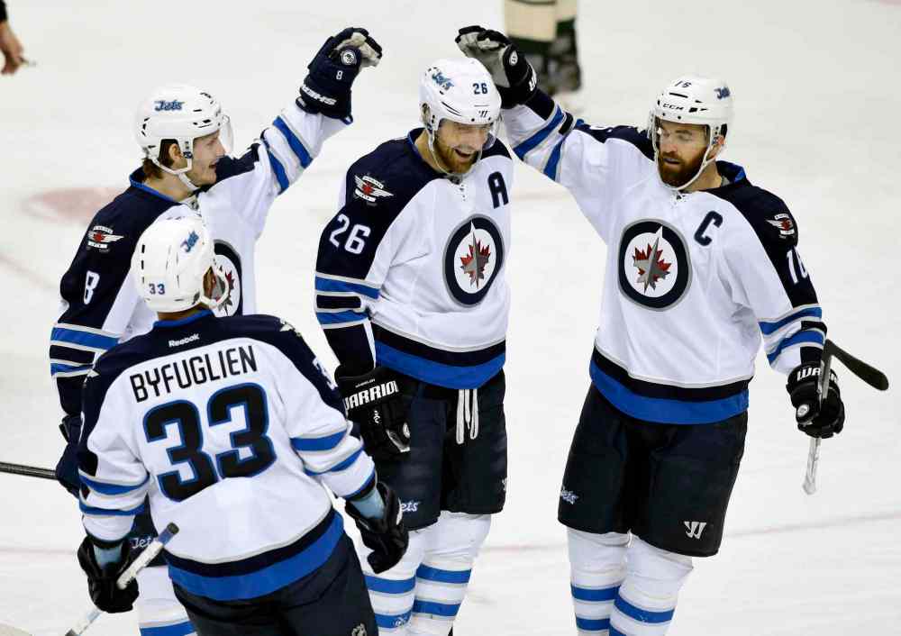 AP Photo/Hannah Foslien
Winnipeg Jets' Dustin Byfuglien (33), Jacob Trouba (8) and Andrew Ladd (16) congratulate right wing Blake Wheeler (26) on a goal against the Minnesota Wild during the first period of an NHL hockey game Friday, Jan. 15, 2016, in St. Paul, Minn.