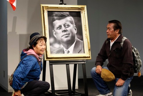 A Japanese couple pose with a portrait of the late U.S. President John F. Kennedy at a memorial venue specially set for his Japanese fans in Tokyo Friday, Nov. 22, 2013, to pay their respects to mark the 50th anniversary of his assassination. Japanese JFK fans took photos with his portrait, folded paper cranes and watched his inaugural ceremony on a monitor Friday to express admiration on the anniversary. (AP Photo/Shuji Kajiyama)