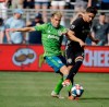 Seattle Sounders midfielder Nicolas Lodeiro, left, and Sporting Kansas City midfielder Felipe Gutierrez battle for the ball during the first half of an MLS soccer match Sunday, May 26, 2019, in Kansas City, Kan. (AP Photo/Charlie Riedel)