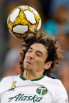 Portland Timbers defender Zarek Valentin, front, and Sporting Kansas City midfielder Gianluca Busio battle for the ball during the first half of an MLS soccer game Sunday, Sept. 29, 2019, in Kansas City, Kan. (AP Photo/Charlie Riedel)