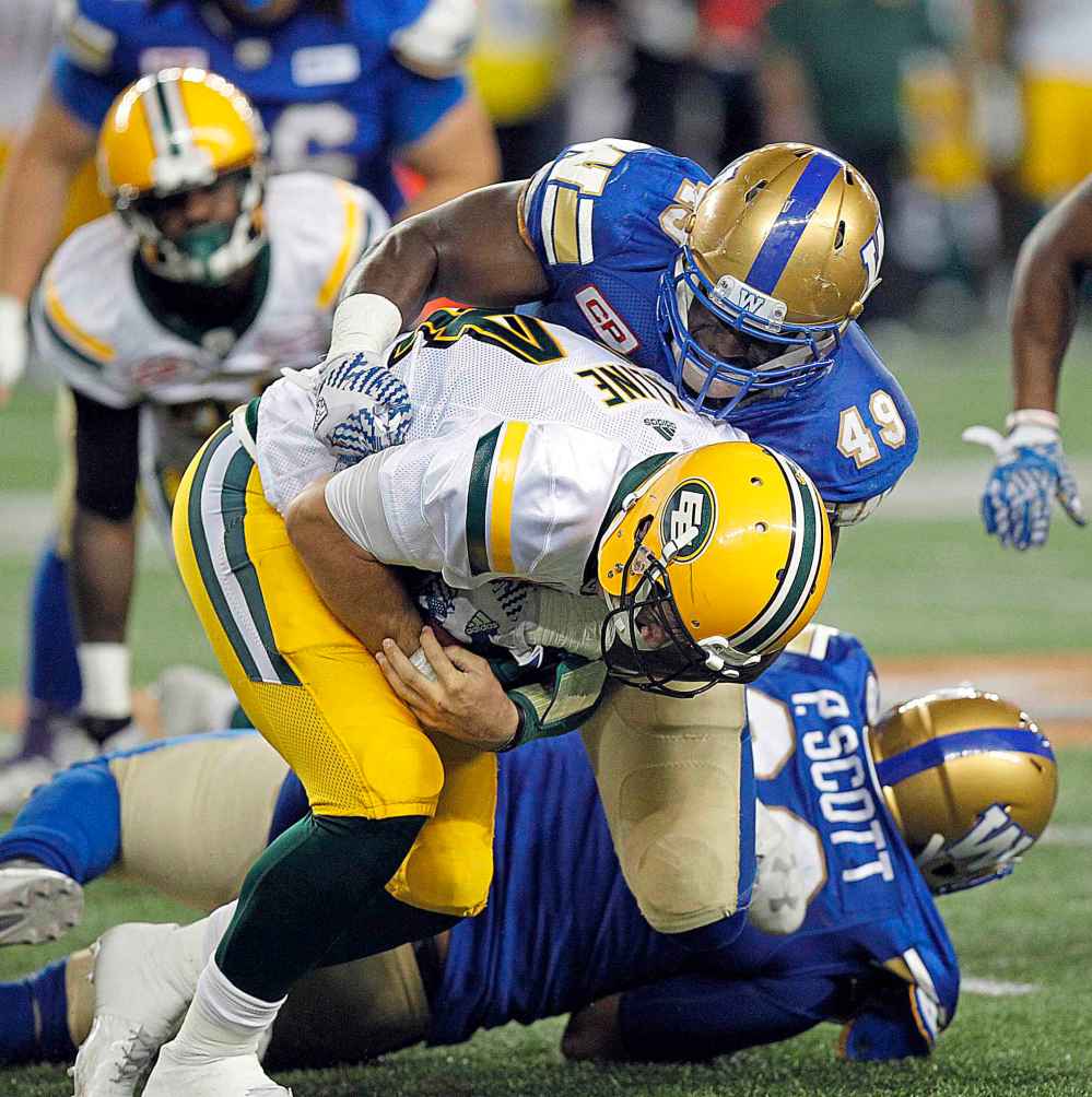 PHIL HOSSACK / WINNIPEG FREE PRESS
Edmonton Eskimos' quarterback quarterback Zach Kline goes down under Winnipeg Blue Bombers' Shayon Green.