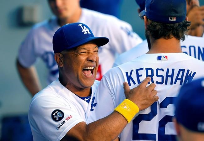 Los Angeles Dodgers manager Dave Roberts, left, jokes around with Clayton Kershaw prior to a baseball game against the San Francisco Giants Saturday, Sept. 7, 2019, in Los Angeles. (AP Photo/Mark J. Terrill)