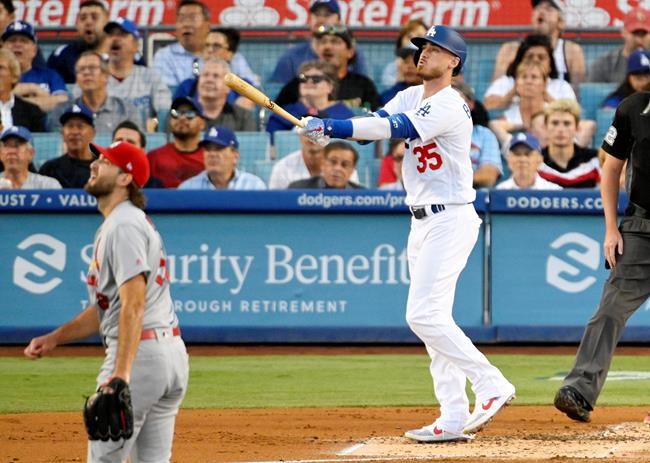 Los Angeles Dodgers' Cody Bellinger, right, heads to first as he hits a three-run home run as St. Louis Cardinals starting pitcher Michael Wacha watches during the first inning of a baseball game Monday, Aug. 5, 2019, in Los Angeles. (AP Photo/Mark J. Terrill)