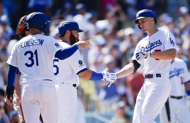 Los Angeles Dodgers' Corey Seager, right, celebrates with Joc Pederson, left, and Russell Martin after a three-run home run during the fifth inning of a baseball game against the San Francisco Giants in Los Angeles, Sunday, Sept. 8, 2019. (AP Photo/Kelvin Kuo)
