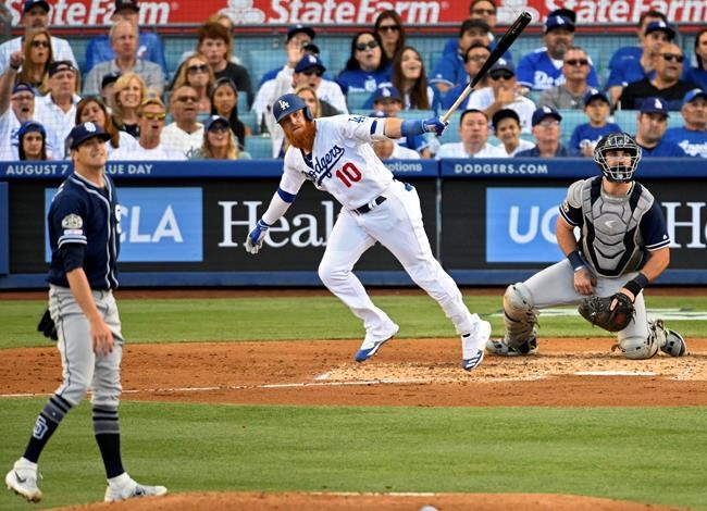 Los Angeles Dodgers' Justin Turner runs to first after hitting a solo home run off San Diego Padres starting pitcher Cal Quantrill, left, during the fourth inning of a baseball game Saturday, Aug. 3, 2019, in Los Angeles. (AP Photo/Mark J. Terrill)