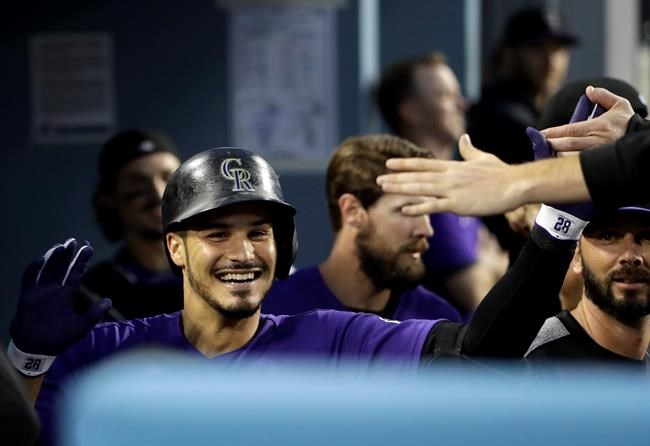 Colorado Rockies' Nolan Arenado celebrates his solo home run with teammates in the dugout during the fourth inning of the team's baseball game against the Los Angeles Dodgers on Friday, June 21, 2019, in Los Angeles. (AP Photo/Marcio Jose Sanchez)