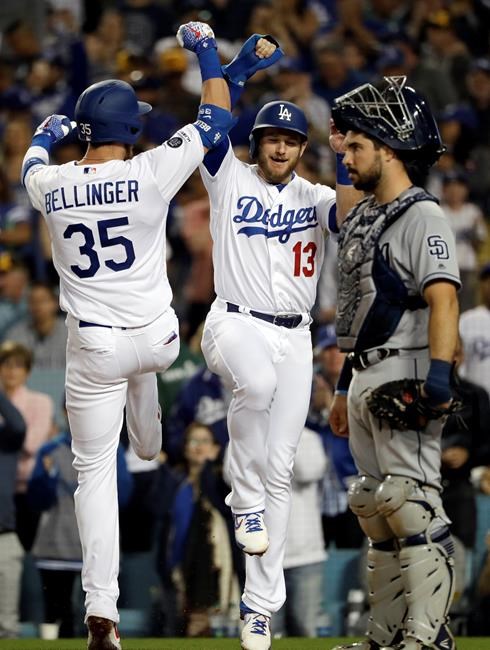 Los Angeles Dodgers' Cody Bellinger (35) celebrates his two-run home run at home plate with teammate Max Muncy (13) next to San Diego Padres catcher Austin Hedges during the third inning of a baseball game Tuesday, May 14, 2019, in Los Angeles. (AP Photo/Marcio Jose Sanchez)