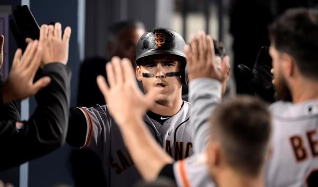 San Francisco Giants' Tyler Austin is congratulated by teammates after hitting a solo home run during the fourth inning of the team's baseball game against the Los Angeles Dodgers on Wednesday, June 19, 2019, in Los Angeles. (AP Photo/Mark J. Terrill)