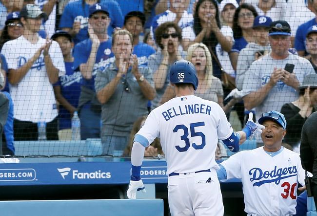 Los Angeles Dodgers' Cody Bellinger gets congratulations from manager Dave Roberts, right, after Bellinger hits a solo home run against the Chicago Cubs during the sixth inning of a baseball game in Los Angeles, Sunday, June 16, 2019. (AP Photo/Alex Gallardo)