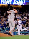 Los Angeles Dodgers' Cody Bellinger, rear, rounds third after hitting a two-run home run off San Francisco Giants relief pitcher Dereck Rodriguez, foreground, during the seventh inning of a baseball game Wednesday, June 19, 2019, in Los Angeles. (AP Photo/Mark J. Terrill)