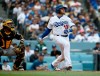 CORRECTS TO FIFTH INNING NOT FOURTH Los Angeles Dodgers' Max Muncy, right, hits an RBI single with Pittsburgh Pirates catcher Elias Diaz watching during the fifth inning of a baseball game in Los Angeles, Sunday, April 28, 2019. (AP Photo/Alex Gallardo)