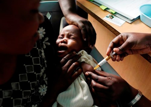 FILE - In this Oct. 30, 2009 file photo, a mother holds her baby receiving a new malaria vaccine as part of a trial at the Walter Reed Project Research Center in Kombewa in Western Kenya. The World Health Organization said Tuesday April 23, 2019, that Malawi has become the first country to introduce a pilot program vaccinating children against malaria using the only licensed vaccine to protect against the mosquito-spread disease. Although the vaccine only protects about one third of children who are immunized, those who get the shot are likely to have less severe cases of malaria. (AP Photo/Karel Prinsloo, File)
