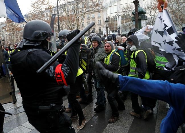 FILE - In this Saturday, Dec. 8, 2018 file photo, police officers clash with demonstrators wearing yellow vests in Paris. A European human rights official said on Wednesday Jan. 30, 2019, that she is