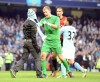 Manchester City's Joe Hart, second left, stops a fan, left, who walks onto the pitch to confront Manchester United's Rio Ferdinand,background,with Manchester City's Carlos Tevez hold Ferdinand back, during their Premier League soccer match at the Etihad Stadium in Manchester, England, Sunday Dec. 9, 2012. (AP Photo/Clint Hughes)