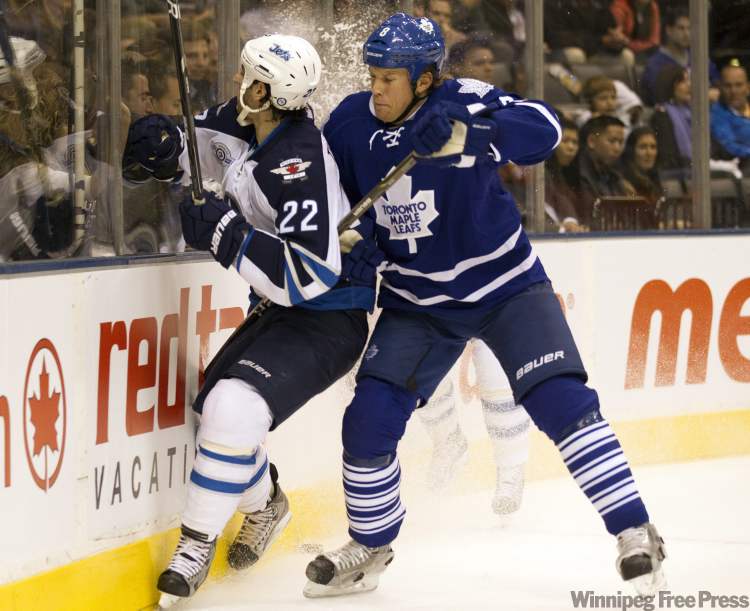 Frank Gunn / The Canadian Press
Toronto Maple Leafs defenceman Mike Komisarek (right) takes Winnipeg Jets' Chris Thorburn (22) into the boards in first period NHL action in Toronto on Wednesday.