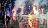 In this photo taken on Saturday, Nov. 2, 2019, Masked Hertha fans burn Union t-shirts on the net, in Berlin. Union Berlin is toasting goalkeeper Rafal Gikiewicz for his bravery in stopping his own masked fans from reaching Hertha Berlin supporters after the sides’ fiery Berlin derby on Saturday. Gikiewicz angrily pushed one masked pitch invader back and urged others to return to their block. (Britta Pedersen/dpa via AP)