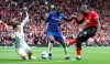 Manchester United's Romelu Lukaku, right, has a shot blocked by Chelsea goalkeeper Kepa Arrizabalaga, left, and Antonio Rudiger during their English Premier League soccer match at Old Trafford, Manchester, England, Sunday, April 28, 2019. (Martin Rickett/PA via AP)