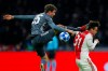 FILE - In this Wednesday, Dec. 12, 2018 file photo, Ajax's Nicolas Tagliafico, right, is fouled by Bayern's Thomas Mueller during the Champions League group E soccer match between Ajax and FC Bayern Munich at the Johan Cruyff Arena in Amsterdam, Netherlands. Bayern Munich forward Thomas Mueller has been banned for both games against Liverpool in the Champions League round of 16. UEFA says its disciplinary panel imposed a two-game ban for Mueller's red card after a bad tackle against Ajax last month. (AP Photo/Peter Dejong, File)