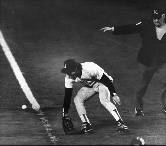 FILE - In this Oct. 25, 1986, file photo, Boston Red Sox first baseman Bill Buckner misplays the ball during during Game 6 of the World Series against the New York Mets. Buckner, a star hitter who became known for making one of the most infamous plays in major league history, has died. He was 69. Buckner's family said in a statement that he died Monday, May 27, 2019, after a long battle with dementia. (Stan Grossfeld/The Boston Globe via AP, File)