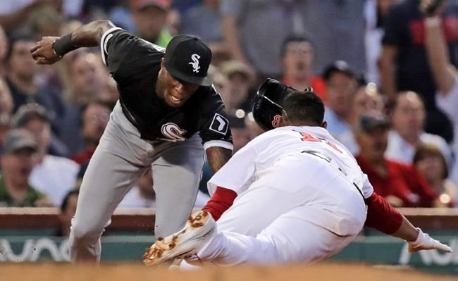 Chicago White Sox shortstop Tim Anderson, left, tags out Boston Red Sox's Rafael Devers, who was caught off third base, during the fourth inning of a baseball game at Fenway Park in Boston, Monday, June 24, 2019. (AP Photo/Charles Krupa)