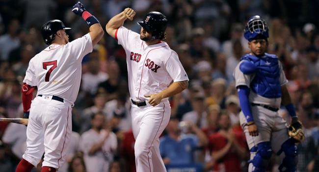 Boston Red Sox's Sam Travis, center, is congratulated by Christian Vazquez (7) after his two run home run off Kansas City Royals pitcher Mike Montgomery during the third inning of a baseball game at Fenway Park in Boston, Monday, Aug. 5, 2019. At right is Kansas City Royals catcher Meibrys Viloria.(AP Photo/Charles Krupa)