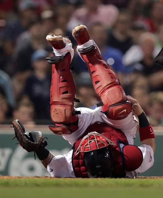 Boston Red Sox catcher Christian Vazquez grabs his knee as he rolls on his back after getting hit with a pitch during the ninth inning of the team's baseball game against the Tampa Bay Rays at Fenway Park in Boston, Wednesday, July 31, 2019. After an injury delay, Vazquez stayed in the game. (AP Photo/Charles Krupa)