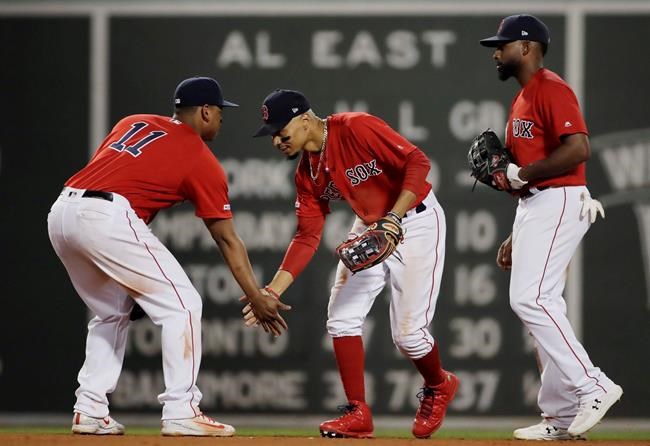 Boston Red Sox's Mookie Betts celebrates with Rafael Devers (11) as Jackie Bradley Jr. stands next to them after a 16-4 win in the team's baseball game against the Los Angeles Angels at Fenway Park, Friday, Aug. 9, 2019, in Boston. (AP Photo/Elise Amendola)