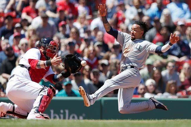 Seattle Mariners' J.P Crawford, right, scores on a double by Daniel Vogelbach as Boston Red Sox's Sandy Leon fields the throw during the first inning of a baseball game in Boston, Saturday, May 11, 2019. (AP Photo/Michael Dwyer)