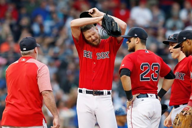 Boston Red Sox pitching coach Dana LeVangie, left, comes to the mound to talk with Chris Sale, center, during the first inning of a baseball game against the Toronto Blue Jays in Boston, Friday, June 21, 2019. (AP Photo/Michael Dwyer)