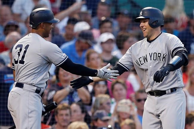 New York Yankees' Austin Romine, right, celebrates his two-run home run with Aaron Hicks (31) during the third inning of a baseball game against the Boston Red Sox in Boston, Sunday, July 28, 2019. (AP Photo/Michael Dwyer)