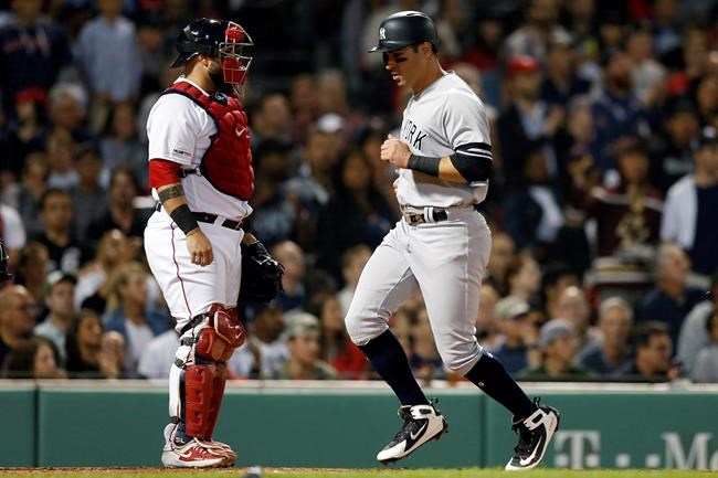 New York Yankees' Mike Tauchman, right, scores in front of Boston Red Sox's Sandy Leon on an RBI-single by Aaron Judge during the third inning of a baseball game in Boston, Sunday, Sept. 8, 2019. (AP Photo/Michael Dwyer)