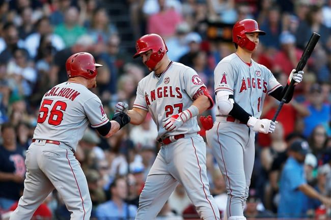 Los Angeles Angels' Mike Trout (27) celebrates his two-run home run that also drove in Kole Calhoun (56) as Shohei Ohtani comes to bat during the sixth inning of a baseball game against the Boston Red Sox in Boston, Saturday, Aug. 10, 2019. (AP Photo/Michael Dwyer)