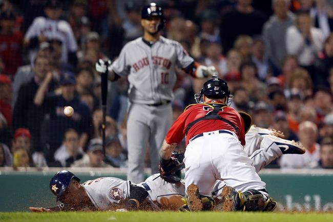 Boston Red Sox's Christian Vazquez (7) can not handle the throw as Houston Astros' Michael Brantley, left, scores on a sacrifice fly by Josh Reddick during the eighth inning of a baseball game in Boston, Friday, May 17, 2019. (AP Photo/Michael Dwyer)