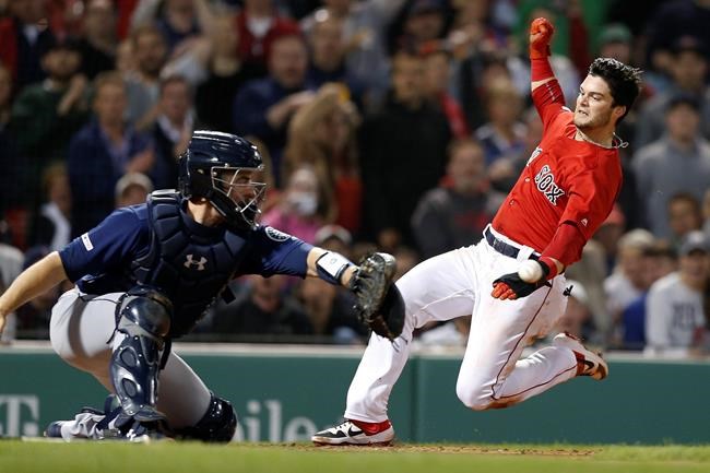 Boston Red Sox's Andrew Benintendi, right, scores on a double by Mitch Moreland as Seattle Mariners' Tom Murphy gets the throw during the fifth inning of a baseball game in Boston, Friday, May 10, 2019. (AP Photo/Michael Dwyer)