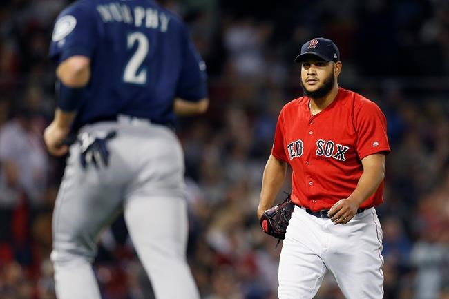 Seattle Mariners' Tom Murphy (2) returns to the dugout as Boston Red Sox's Eduardo Rodriguez walks off the mound after the top of the seventh inning of a baseball game in Boston, Friday, May 10, 2019. (AP Photo/Michael Dwyer)