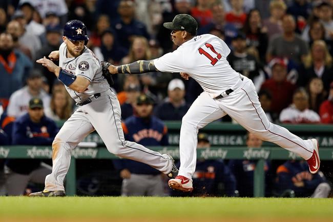 Boston Red Sox's Rafael Devers (11) tags out Houston Astros' Max Stassi in a rundown after a line-out by Alex Bregman during the seventh inning of a baseball game in Boston, Saturday, May 18, 2019. (AP Photo/Michael Dwyer)