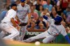 Boston Red Sox's Rafael Devers, left, can not make the play as Toronto Blue Jays' Teoscar Hernandez, right, advances to third base on a throwing error by Josh Taylor on a pickoff attempt at first base during the sixth inning of a baseball game in Boston, Tuesday, July 16, 2019. (AP Photo/Michael Dwyer)