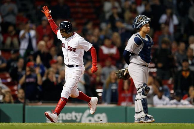 Boston Red Sox's Mookie Betts, left, celebrates his solo home run behind New York Yankees' Gary Sanchez during the eighth inning of a baseball game in Boston, Sunday, Sept. 8, 2019. (AP Photo/Michael Dwyer)