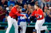 Boston Red Sox's Christian Vazquez, right, celebrates with third base coach Carlos Febles after hitting a walkoff home run as Toronto Blue Jays' Jordan Romano (68) enters the dugout during the 10th inning of a baseball game in Boston, Friday, June 21, 2019. (AP Photo/Michael Dwyer)