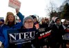 United States Department of Agriculture employee Lori Lodato, of Wilmington, Mass., display placards during a rally by federal employees and supporters, Thursday, Jan. 17, 2019, in front of the Statehouse in Boston, held to call for an end of the partial shutdown of the federal government. (AP Photo/Steven Senne)