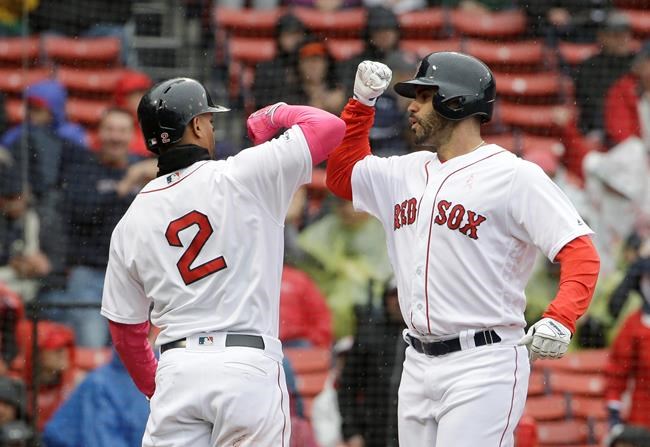 Boston Red Sox's Xander Bogaerts, left, welcomes home J.D. Martinez, right, after Martinez hit a homerun off a pitch by Seattle Mariners' Marco Gonzales during the first inning of a baseball game at Fenway Park, Sunday, May 12, 2019, in Boston. (AP Photo/Steven Senne)