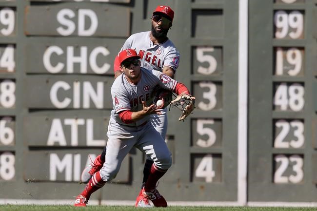 Los Angeles Angels' Brian Goodwin, behind, catches a fly ball by Boston Red Sox's Chris Owings as Angels' David Fletcher, front, scrambles in the sixth inning of a baseball game at Fenway Park, Sunday, Aug. 11, 2019, in Boston. (AP Photo/Steven Senne)