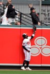Baltimore Orioles left fielder Dwight Smith Jr., and a fan cannot catch a home run ball hit by Oakland Athletics' Chris Davis for two runs in the fourth inning of a baseball game, Thursday, April 11, 2019, in Baltimore. (Kenneth K. Lam/The Baltimore Sun via AP)
