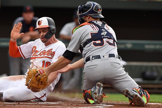 Baltimore Orioles' Trey Mancini, left, is safe at the plate, as Detroit Tigers catcher John Hicks tries to make the tag, on a double by Renato Nunez during the first inning of a baseball game Wednesday, May 29, 2019, in Baltimore. (AP Photo/Gail Burton)