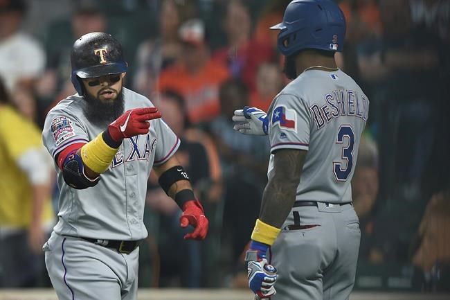 Texas Rangers Rougned Odor, left, motions to Delino DeShields after hitting a three-run home run against the Baltimore Orioles in the first inning of a baseball game, Saturday, Sept. 7, 2019, in Baltimore. (AP Photo/Gail Burton)