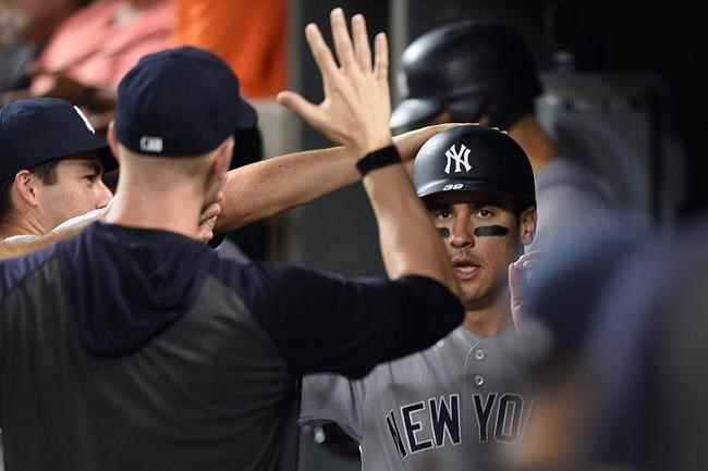 New York Yankees' Mike Tauchman is congratulated after scoring against the Baltimore Orioles in the fifth inning of a baseball game, Monday, Aug. 5, 2019, in Baltimore. (AP Photo/Gail Burton)