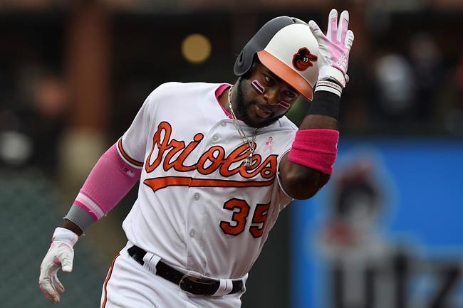 Baltimore Orioles' Dwight Smith Jr. pats his helmet while rounding third on his two-run home run against the Los Angeles Angels in the third inning of a baseball game, Sunday, May 12, 2019, in Baltimore. (AP Photo/Gail Burton)