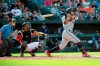 Minnesota Twins left fielder Eddie Rosario, right, hits a solo home run in the second inning of a baseball game against the Baltimore Orioles, Saturday, April 20, 2019, in Baltimore. (AP Photo/Tommy Gilligan)