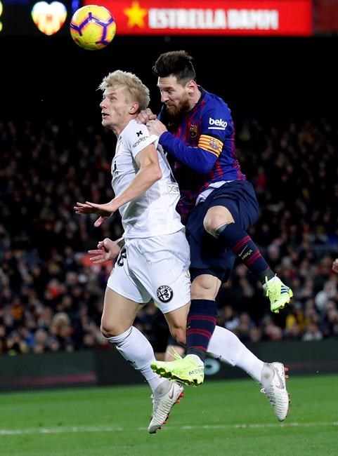FC Barcelona's Lionel Messi, right, heads for the ball with Valencia's Carlos Soler during the Spanish La Liga soccer match between FC Barcelona and Valencia at the Camp Nou stadium in Barcelona, Spain, Saturday, Feb. 2, 2019. (AP Photo/Manu Fernandez)