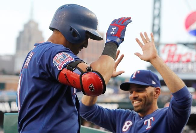 Texas Rangers' Ronald Guzman, left, is greeted by manager Chris Woodward after a solo home run during the sixth inning of the team's baseball game against the Detroit Tigers, Tuesday, June 25, 2019, in Detroit. (AP Photo/Carlos Osorio)